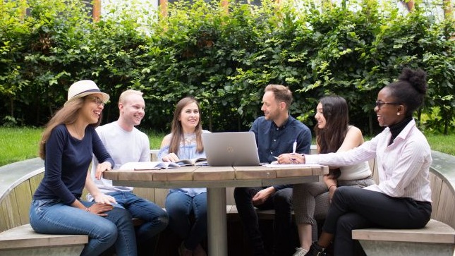 Students studying and socialising outdoors in Glasgow Caledonian University courtyard gardens