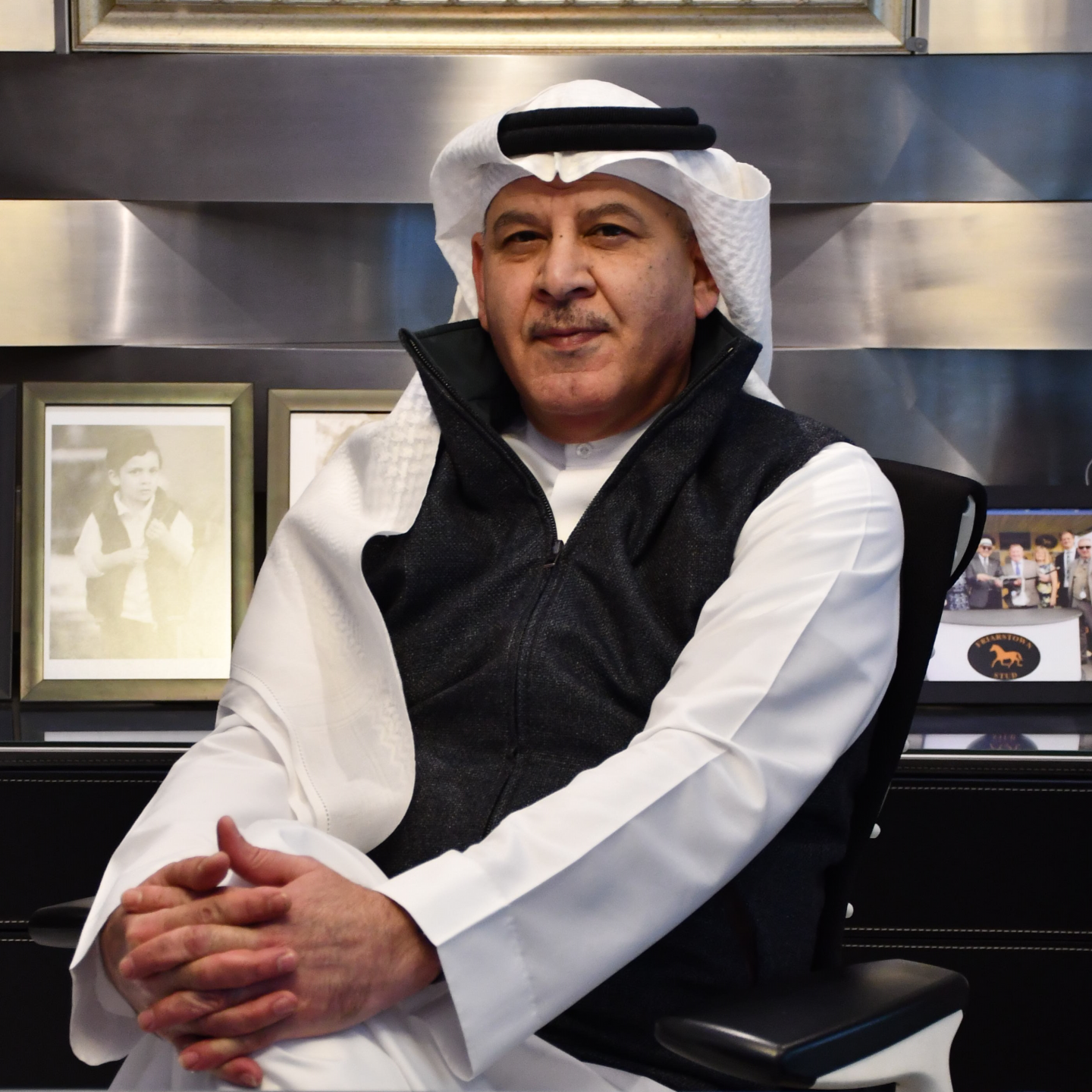 An image of Khalid Abdul Rahim, a GCU alumnus, and founder and chairman of KAR Group, at his office desk, sitting in full traditional dress.