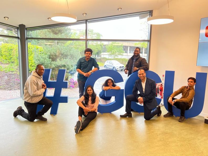 A photo of the students photographed next to a '#GCU' sign, on Glasgow campus.