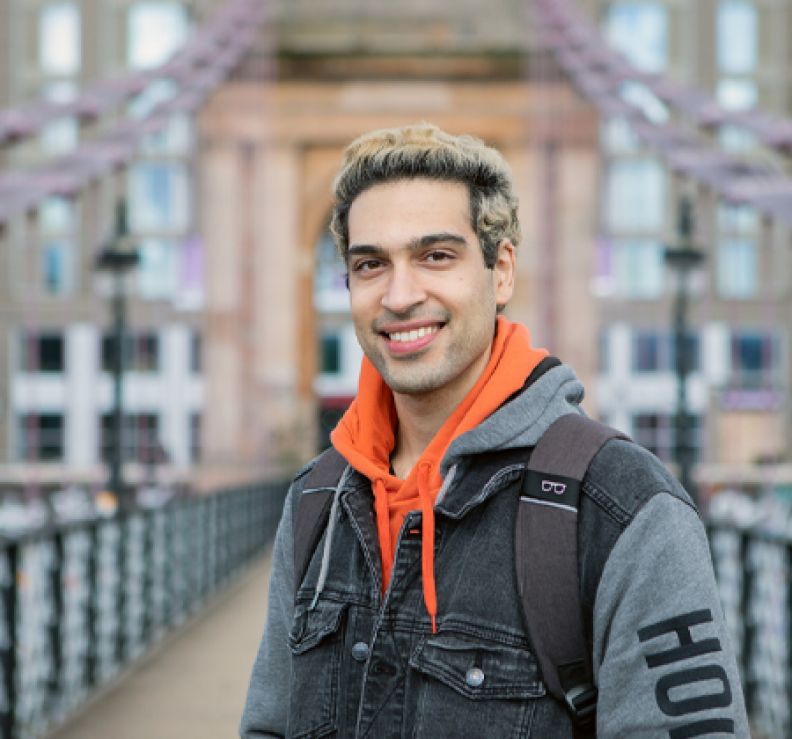 Student standing on a bridge