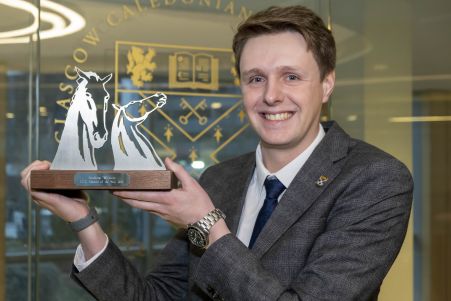 GGCU Alumnus and GCU Alumni of the Year (AOTY) winner Andrew Wilson holding his AOTY award