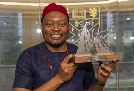 GCU Alumnus and GCU London Alumni of the Year (AOTY) winner Kelvin Alaneme holding his AOTY award