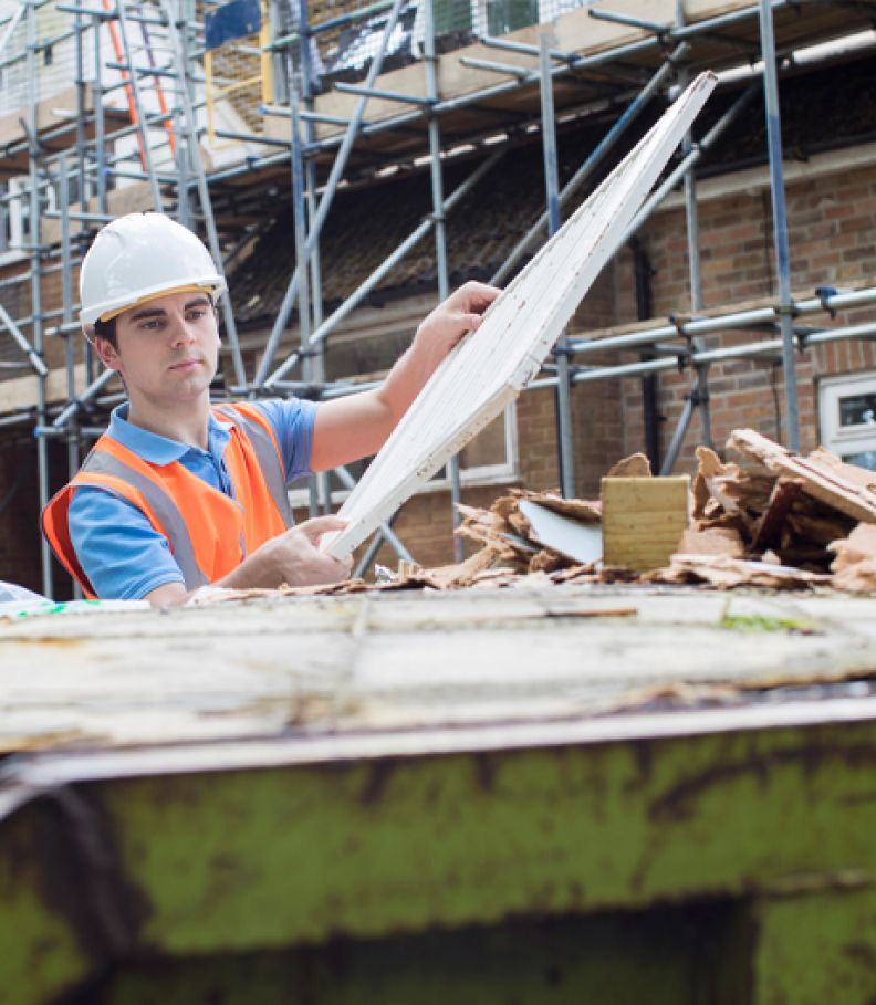 Builder putting waste in to a tip